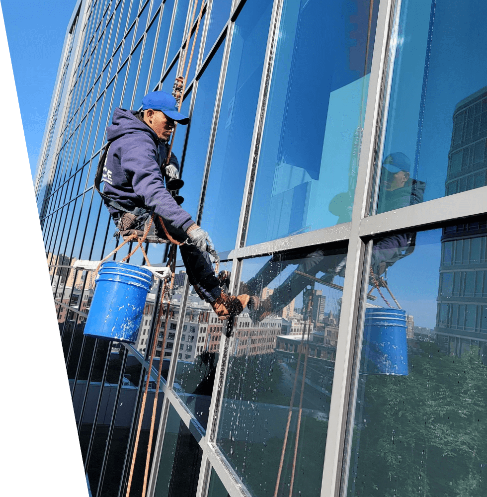 Untitled-design-1-1 (1) man hanging outside building washing windows